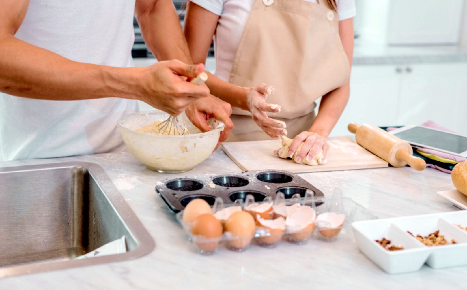 A dad and his daughter baking together at the kitchen counter